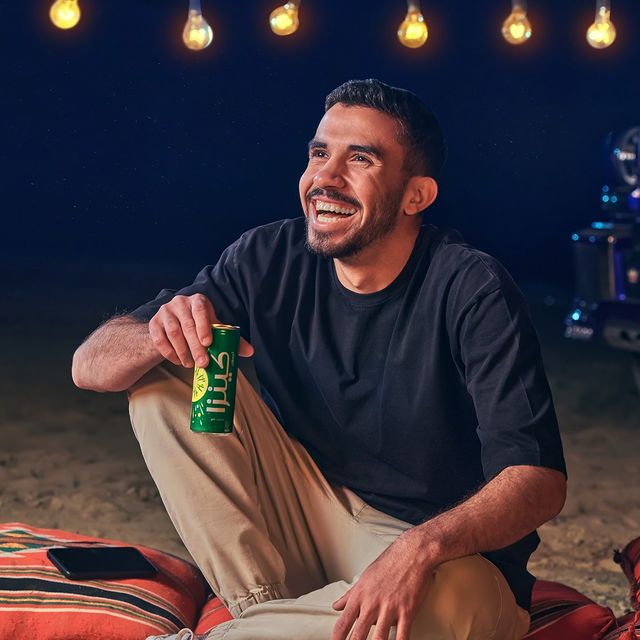  A man laughing while holding green Kinza lemon can 